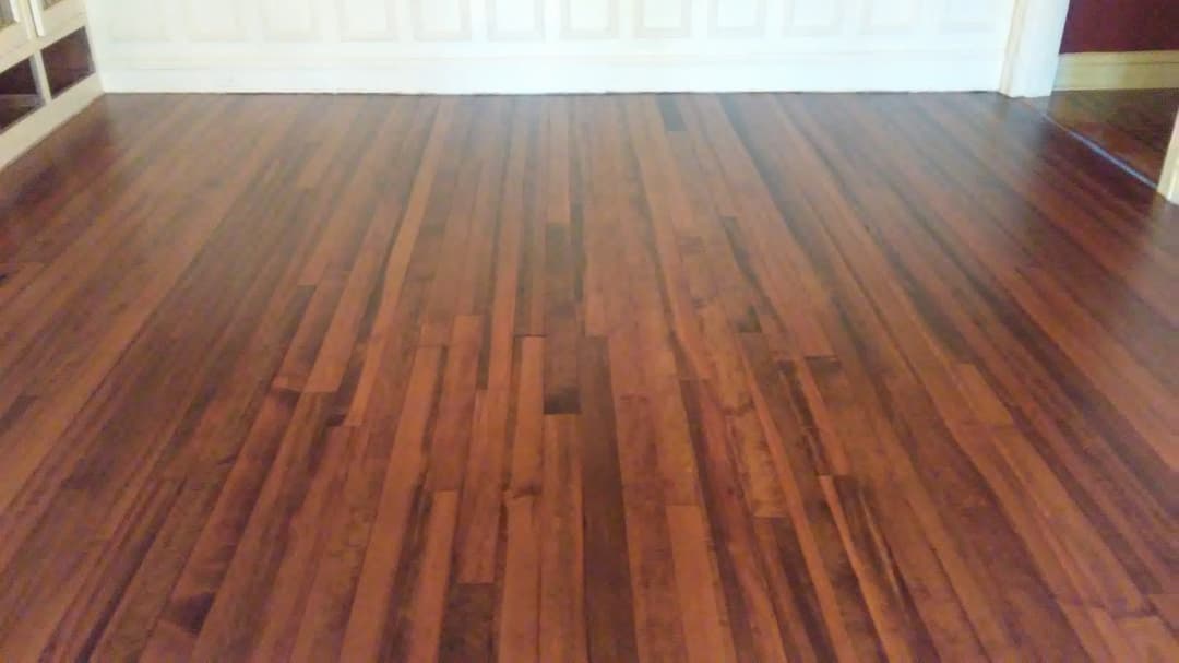 Interior view of polished hardwood flooring with rich brown tones and a smooth finish.