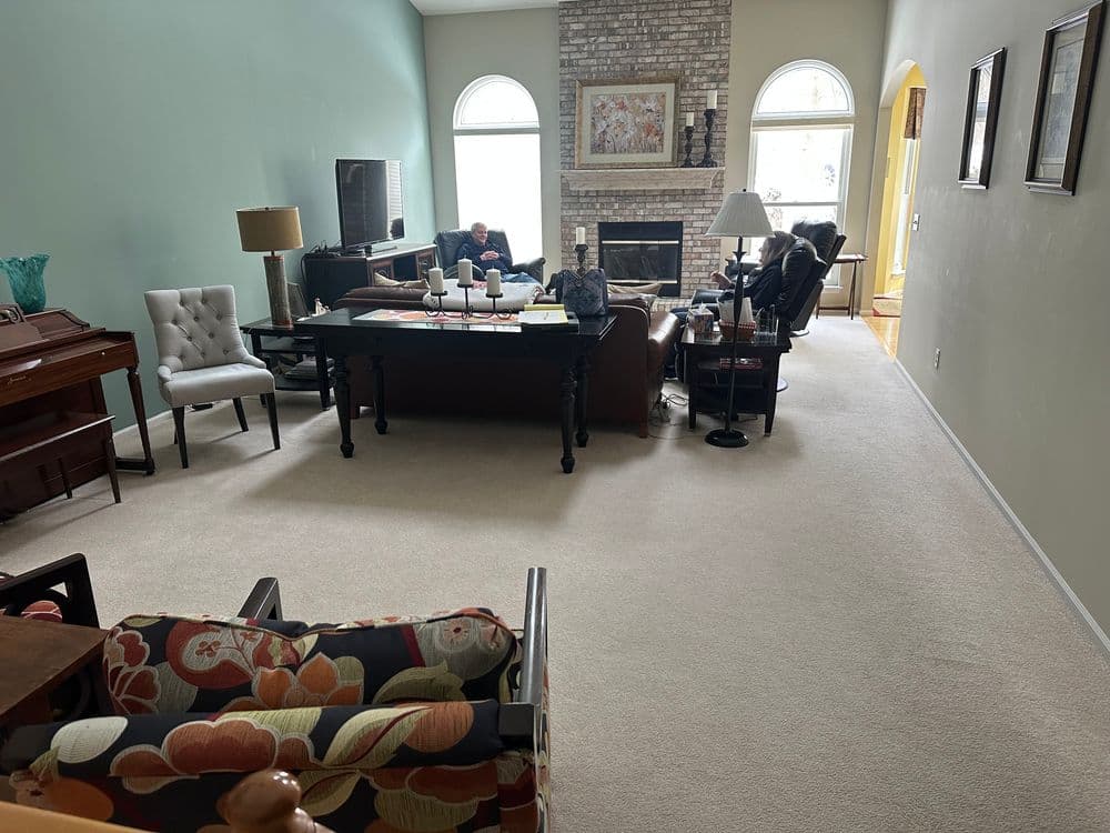 Spacious living room with a fireplace, comfortable seating, and large windows for natural light.
